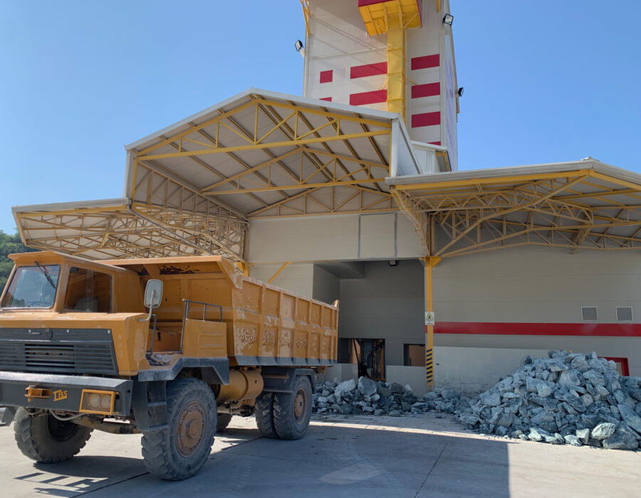 Truck off-loading boulders outside the gravity-fed stone crusher.